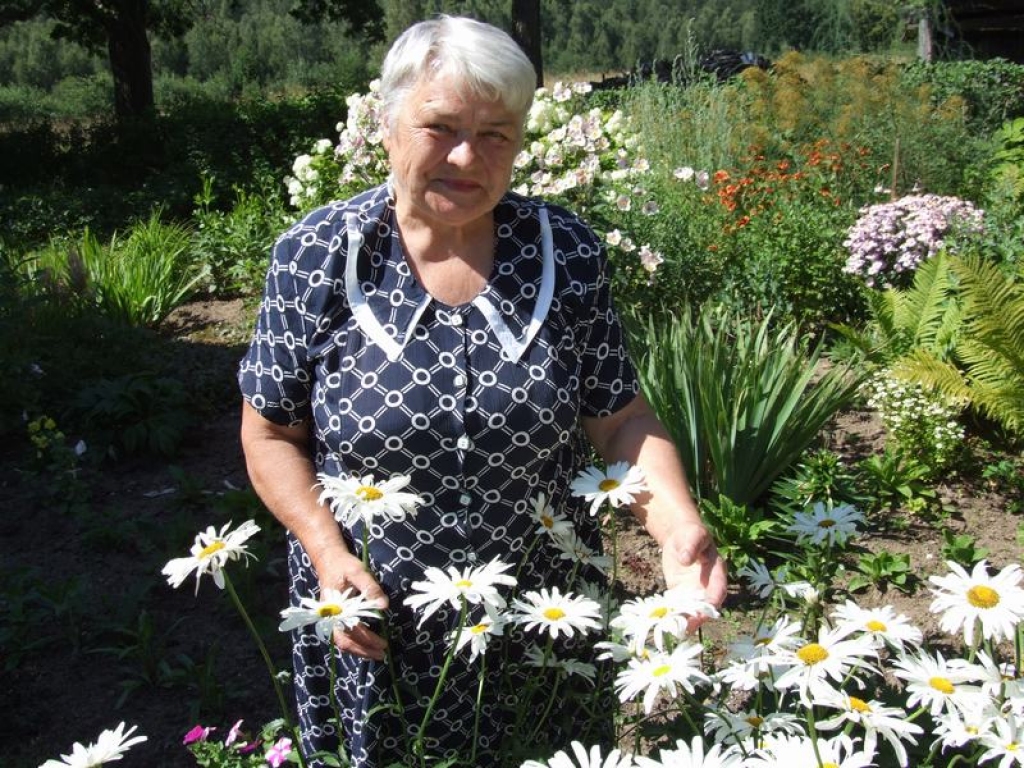 Pašas iekoptajā dārzā. “Upmaļu” mājas, kur dzīvo Strautnieki, slīgst puķēs.