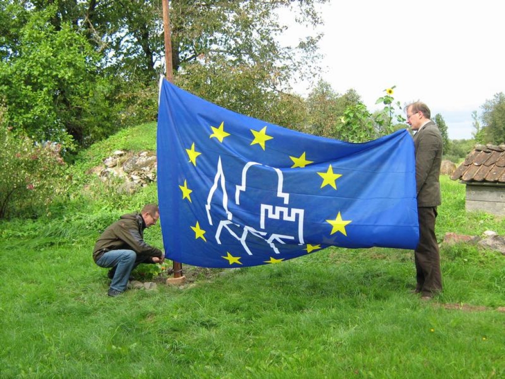 KAROGS MASTĀ. Pilkalnes muižas pagalmā Eiropas kultūras mantojuma karogu mastā velk muižas saimnieks Valdis Tomsons (no kreisās) un Aizkraukles rajona padomes izpilddirektors Guntis Libeks. 