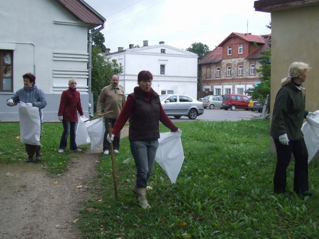 PIRMIE TALCINIEKI. Koknesieši baltajos maisos dodas vāk ap dzelzceļa sliedēm izmētātos atkritumus. 