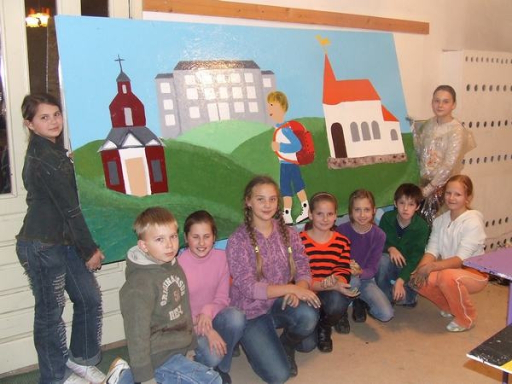 VIENA NO GLEZNĀM. Mazie mākslinieki pie bildes, kurā redzama Neretas vidusskolas, luterāņu un katoļu baznīcas. 