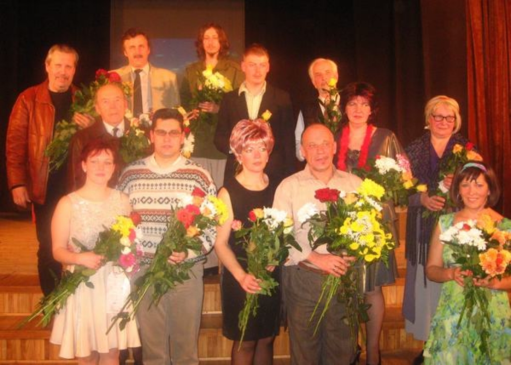 VĒL IZRĀDES VARĀ. Skrīveru teātra aktieri, saņemot ziedus un aplausus, vēl jūtas  kā izrādē. No kreisās — Patrīcija (Aija Ieleja) un Roberts (Uldis Dzērve), aiz viņiem aizmugurē trešajā rindā (no kreisās) stāv Gotfrīds (Juris Kalvišķis) un Otto (Ansis Martinsons).