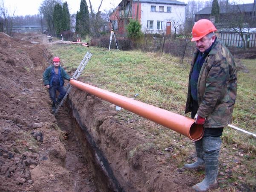 DARBI RIT RAITI. Tiklīdz izrakta tranšeja, SIA “Kombi—D” strādnieki tajā ievieto caurules.