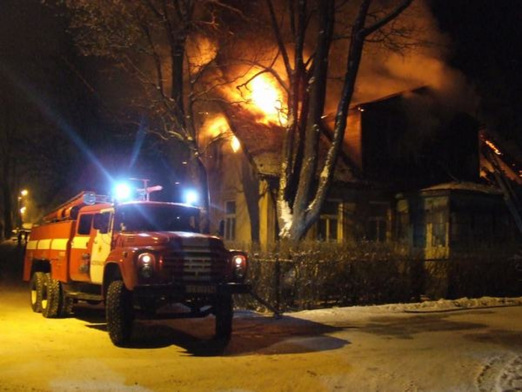 LIESMAS JUMTĀ. Vecās ēkas jumtu strauji apņem liesmas. 