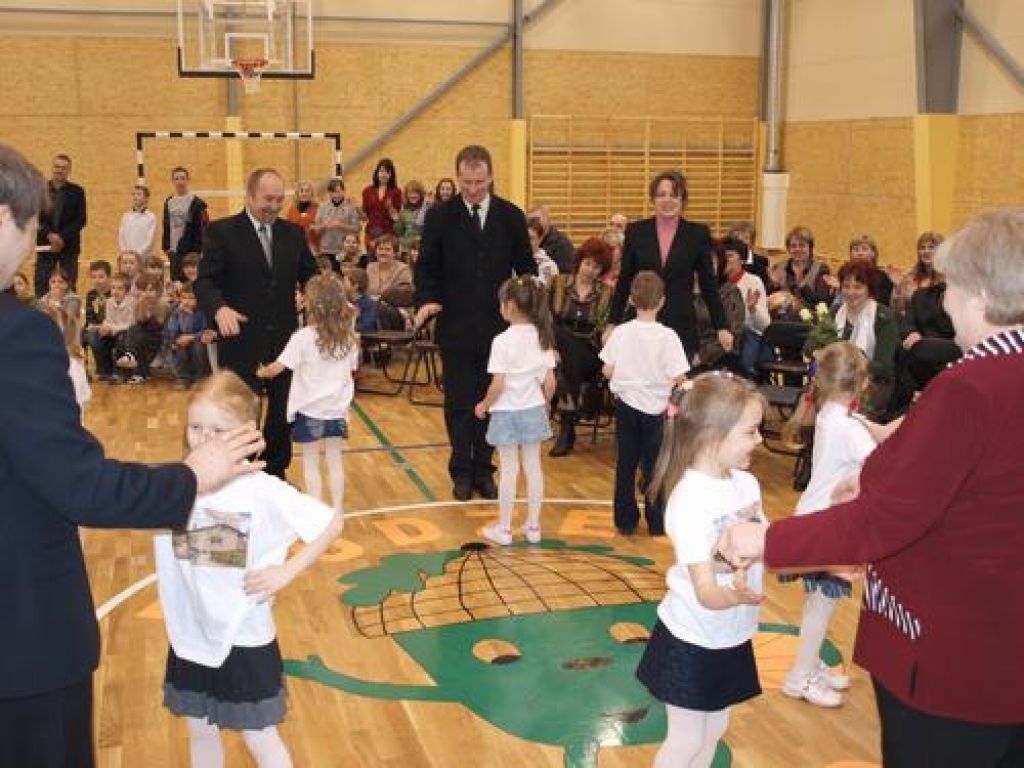 PIRMAIS DANCIS. Sporta zālē pirmo danci griež bērnudārza audzēkņi un pieaugušie. Zāles vidus apli grezno jauns logo — Zīļuks un uzraksts “ Daudzese 2009”.  