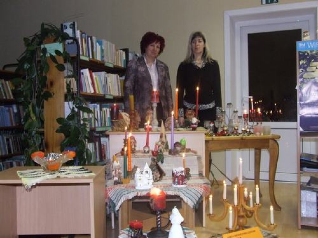 Sveču gaismā. Jaunjelgavas pilsētas bibliotēkas vadītāja Lolita Frīdmane (no kreisās) un izstādes idejas autore bibliotekāre Vita Taškaua. 