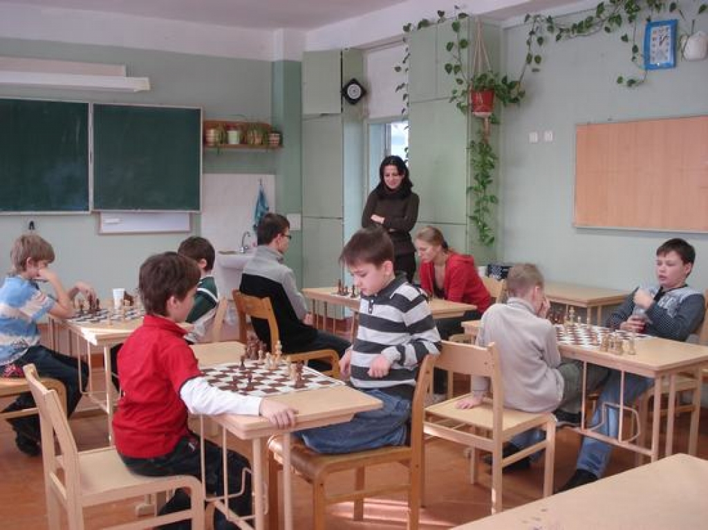 PRĀTA SPĒLE. Spēlē jaunie rīdzinieki  un aizkrauklieši. Viņus vēro šaha trenere Poļina Ni. No labās —  otrās vietas ieguvējs aizkrauklietis Vladislavs Martinovs.