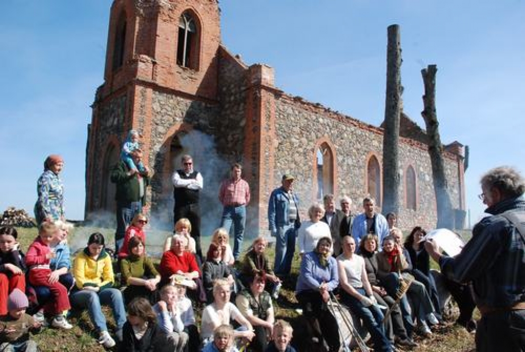 VĒSTURES STUNDA ZEM KLAJAS DEBESS. Talcinieki ieinteresēti noklausījās Gunāra Spīdaiņa (no labās) stāstījumu par Zalves baznīcas vēsturi.