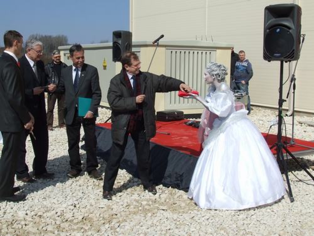 Top vēsture. Graciozā princese, kura simbolizē iespēju no betona radīt arī mākslu, pasniedz simbolikās šķēres firmas “Baumit” pārstāvim. 