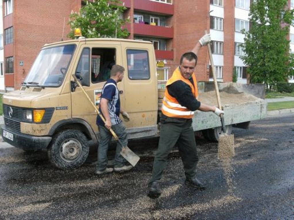 “Padarītā darba apjoms atkarīgs no ceļa seguma bojājumu daudzuma un laika apstākļiem,” teic smagās tehnikas operators Uģis Ķirsis (priekšplānā).