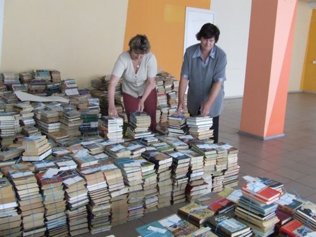 Darba daudz. Lasītāju apkalpošanas nodaļas vadītāja Astrīda Puncule un bibliotēkas vecākā bibliotekāre Ineta Lesiņa grāmatas pārnes uz pagaidu vietu.