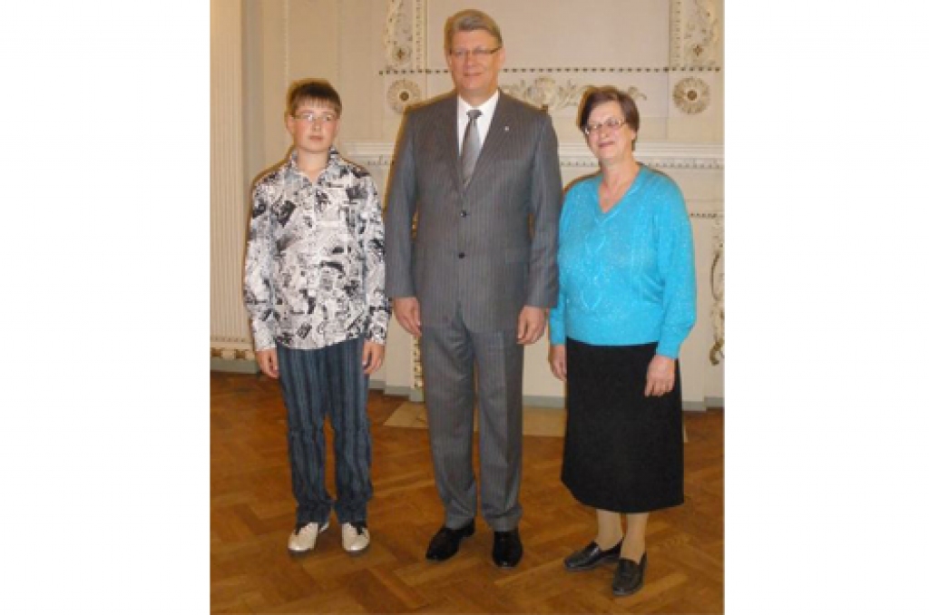 Vēsturiska fotogrāfija. Odzienas pamatskolas 7. klases skolēns Rūdis Eiduks blakus Valsts prezidentam Valdim Zatleram un skolotājai Birutai Irēnai Osītei.