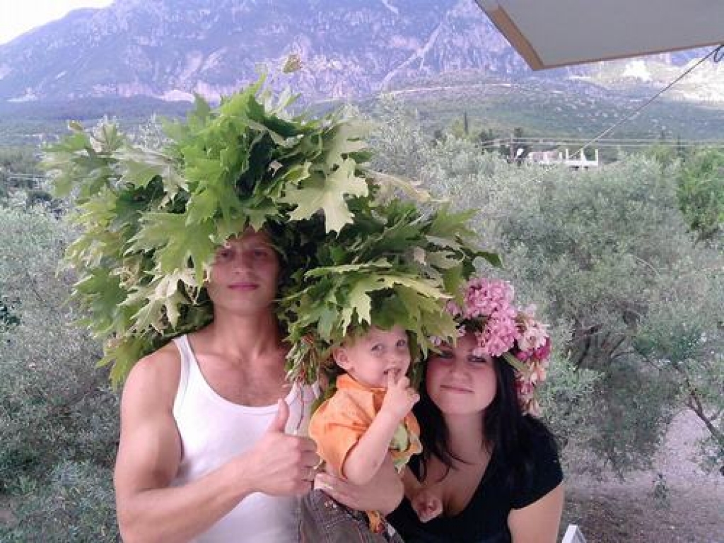 Aivis (no kreisās), mazais Daniels un Līga ar oleandru vainadziņu. Fonā — olīvkoku audzes.