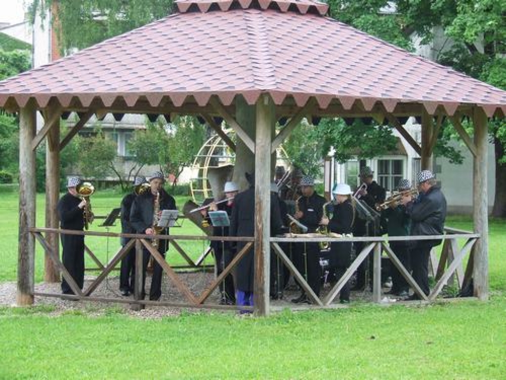 Vieta, kur patverties. Kokneses pūtēju orķestris muzicē zem nojumes. 