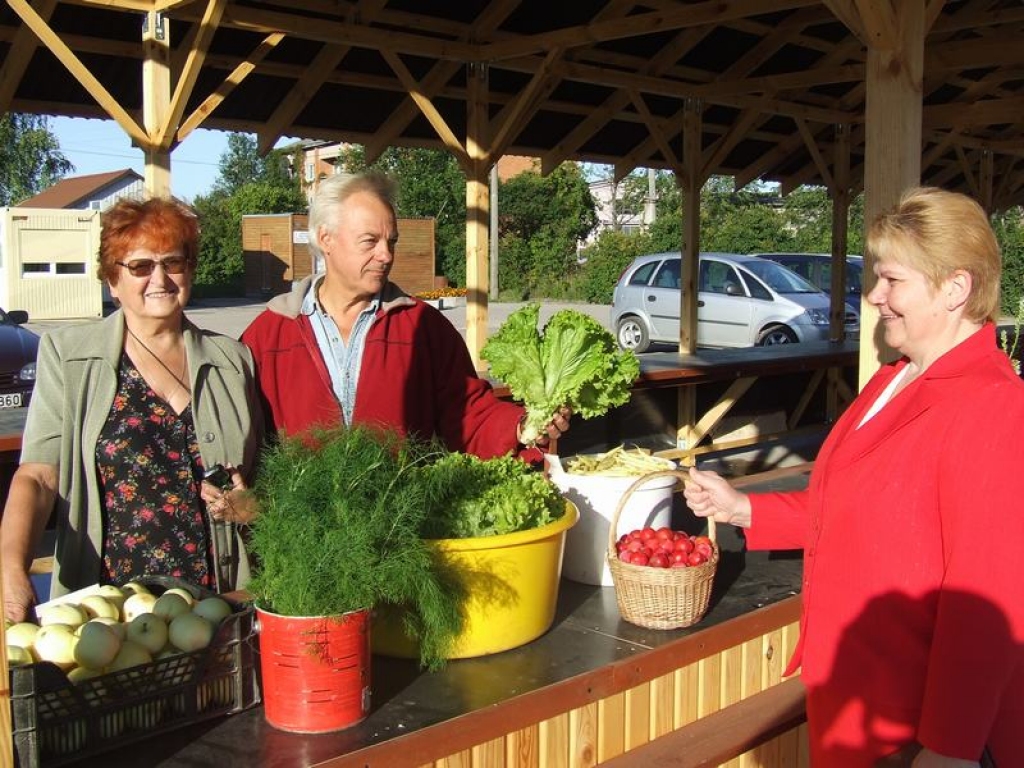 PIRMĀ PIRCĒJA. Paplašinātajā tirgū pirmā pie Kazuša kunga iepirkās aizkraukliete Ainas kundze. Līdzās — tirgus īpašniece Regīna Malahova (pa kreisi).