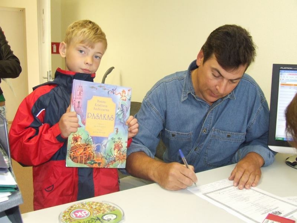 Dots pret dotu. Lai saņemtu mobilo tālruni, Roberts dāvina pasaku grāmatu, bet tētis Guntis Spēlmanis izpilda nepieciešamos dokumentus.