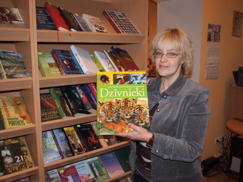 Balva par padarīto. Kurmenes pagasta bibliotēkas vadītāja Gita Skadiņa ar balvu — enciklopēdiju bērniem.