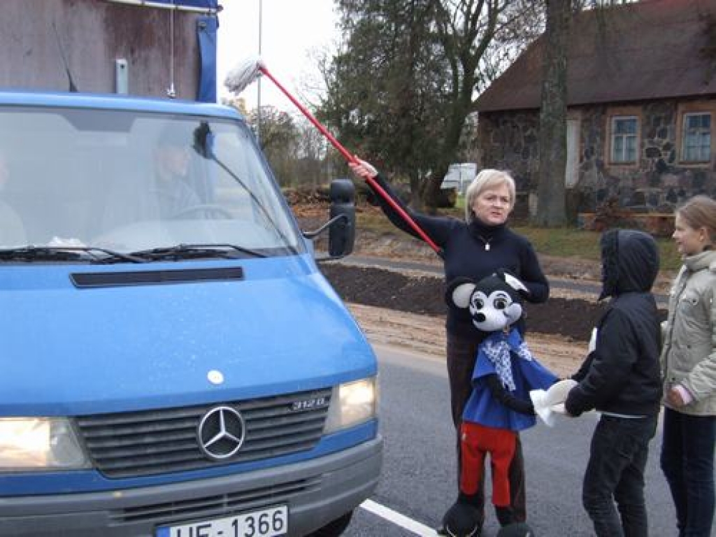 AR ŠAMPANIETI UN LABA VĒLĒJUMIEM. Uz jaunā ceļa autobraucējus sveica Leļļu teātra aktrise Dzintra Duka — Maisaka un Mikipele.