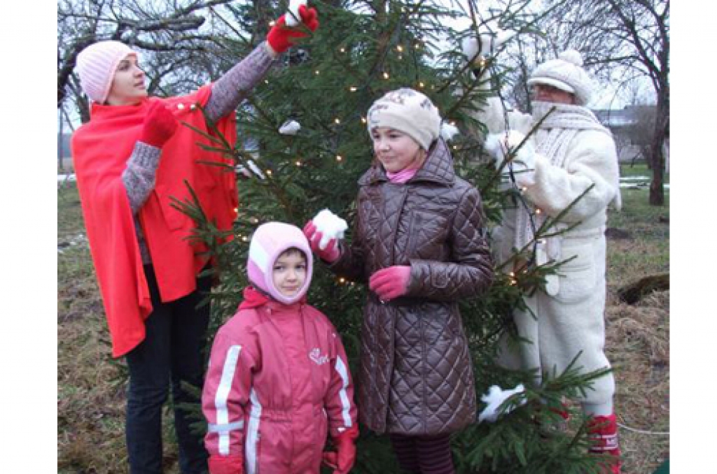 Pušķojot “Dimantu” egli. Sinora (no kreisās), Emija, Megija Lazdiņas un Ziemassvētku ‘‘vecītis’’ — Terēze Kārkla.