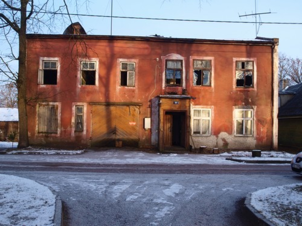 Pilsētas kontrasti. Blakus nesen atjaunotajai novada domes ēkai pamestā un izdemolētā ēka izskatās kā melns traips uz baltas lapas. 