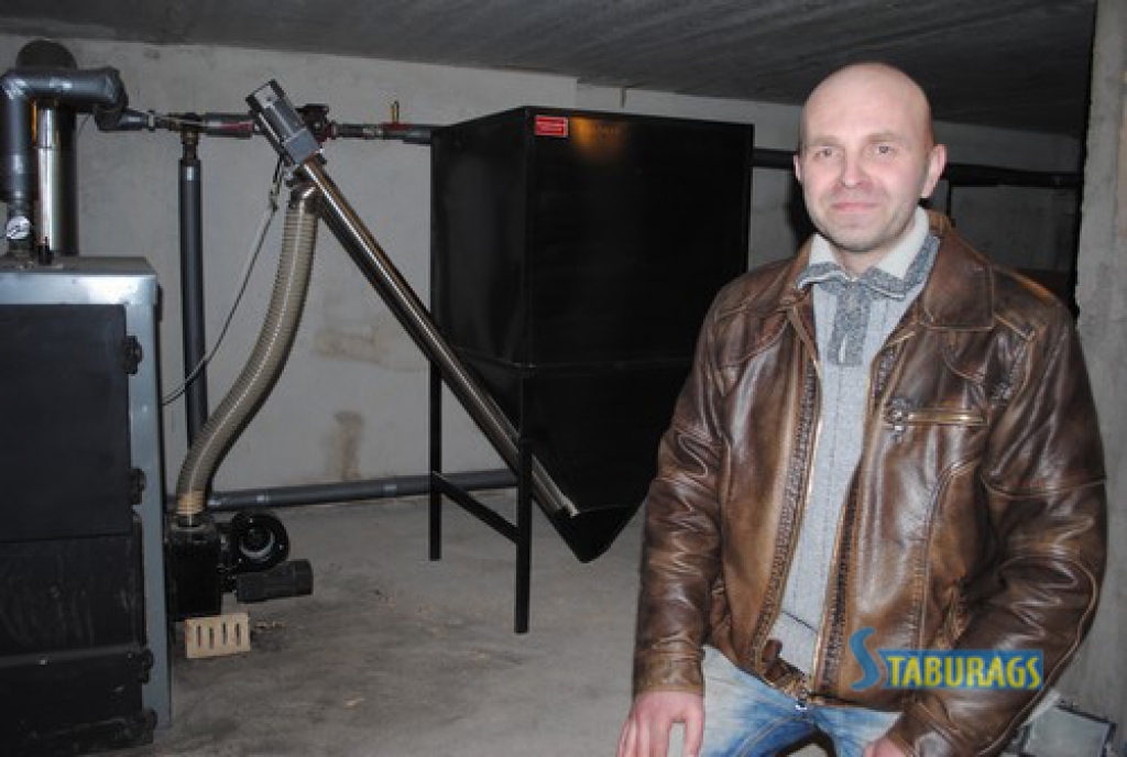 BIRST AUTOMĀTISKI. No granulu tvertnes (pa labi) koka granulas pa caurulēm ik pēc laika sabirst apkures katlā. “Process notiek automātiski — par to gādā elektroniskās “smadzenes”,” stāsta SIA “Silged” pārstāvis Valdis Zablockis. 