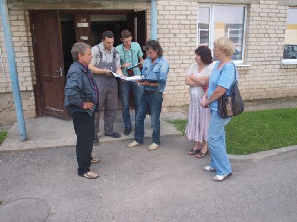 SALĪDZINA DATUS. Mājas vecākā Lonija Podniece (otrā no labās) un apsaimniekotāju biedrības valdes loceklis Jānis Brikmanis (trešais no labās) kopā ar uzņēmuma “Lauma A” pārstāvjiem salīdzina skaitītāju rādījumus. 