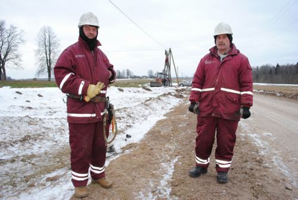 RŪDĪTI VĪRI. Darbu vadītājs Viktors Trups (no kreisās) un pacēlāja vadītājs Dzintars Andrejevs teic, ka ir pieraduši un norūdījušies strādāt nelabvēlīgos laika apstākļos. 
