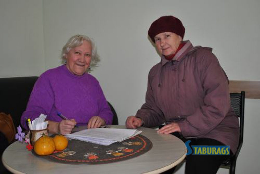 AIZKRAUKLĒ PENSIONĀRI IR AKTĪVI. Aizkraukles novada sociālajā centrā parakstīties atnākušo aizkrauklieti Liju Petrusenko (no labās) sagaida pensionāru biedrības pārstāve Milda Malafejeva. 