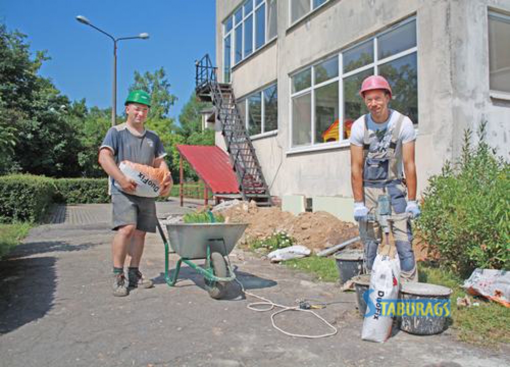 DARBI RIT RAITI. SIA “FF” strādnieki Oskars Stivriņš (no kreisās) un Māris Breicis gatavo mūrjavu putu polistirola plākšņu līmēšanai.