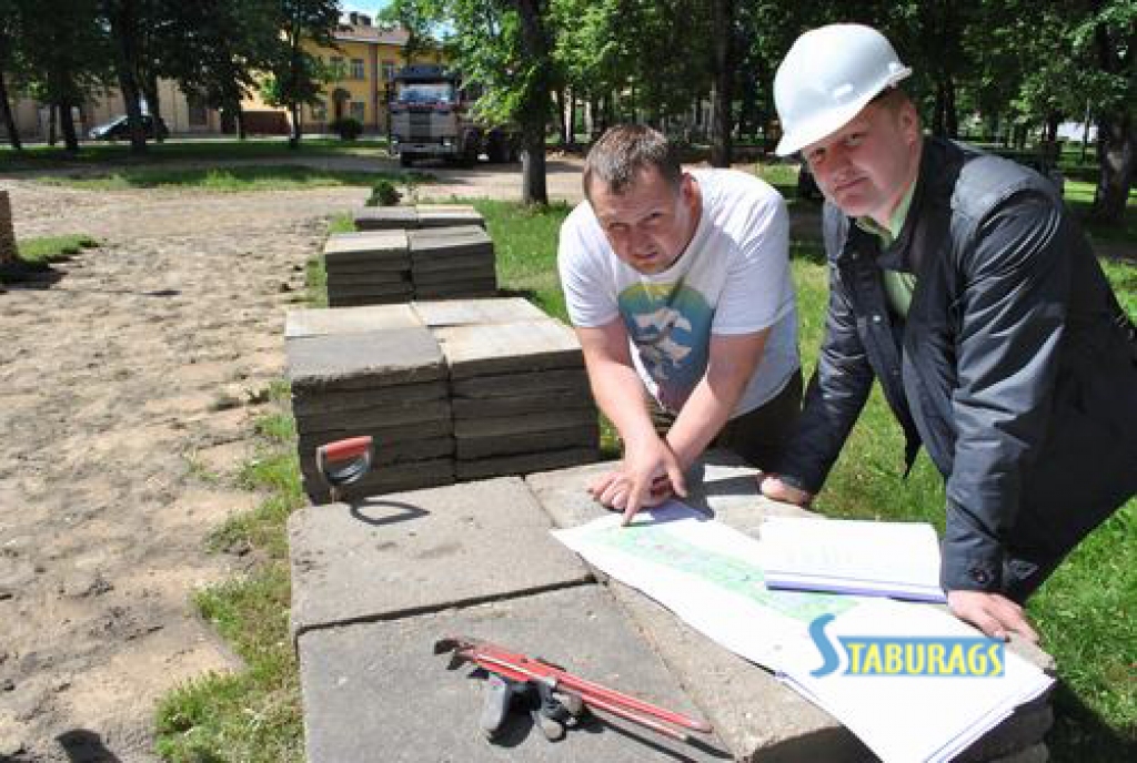 Vispirms pazemē veicamos darbus. Būvdarbu vadītājs Gatis Petrovs (no labās) ar kolēģi apspriež ūdensvada un notekūdeņu sistēmas izvietojumu Jaunjelgavas Vecpilsētas parkā.