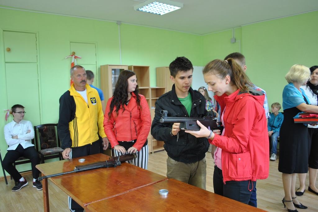 JĀDARA TĀ. Pulciņa “Aktīvais tūrisms+” audzēknis Artūrs Jakovļevs Lanai Zaicevai rāda, kā rīkoties ar pneimatisko šauteni. No kreisās — skolotājs Imants Kravalis. 
Autors: Guna Mikasenoka