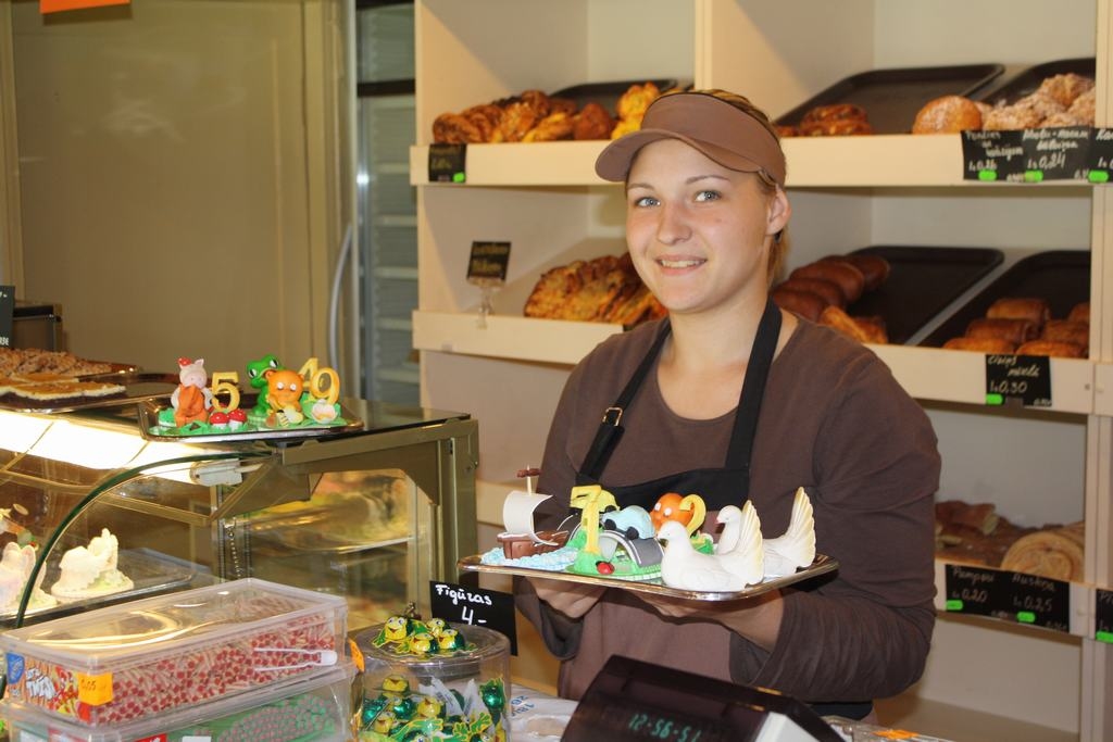 GAIDĪTS IKVIENS. Pārdevēja Iveta Preica pircējus apkalpo smaidot un stāsta par konditorejas īpašajiem piedāvājumiem. 
Autors: Evita Apiņa