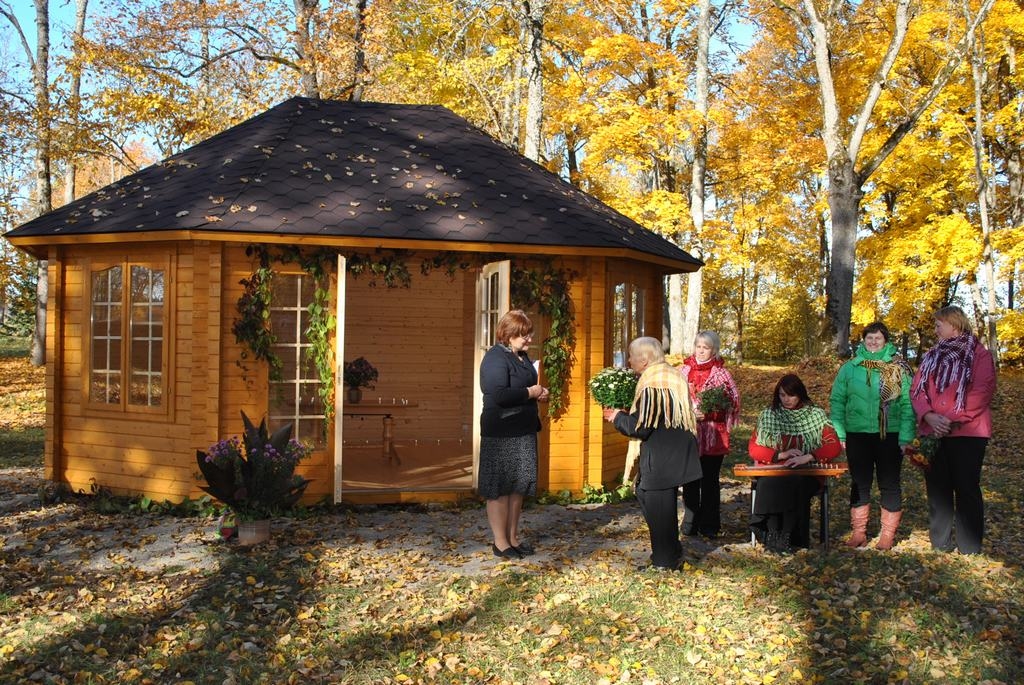 Mūzikas namiņš. Skaista un romantiska Pētera Barisona lapenīte Vīgantes parkā. Atklāšanas pasākumā Ivetu Ločmeli (no kreisās) sveic Seces pagasta folkloras kopas dalībnieces. 
Autors: Līga Patmalniece