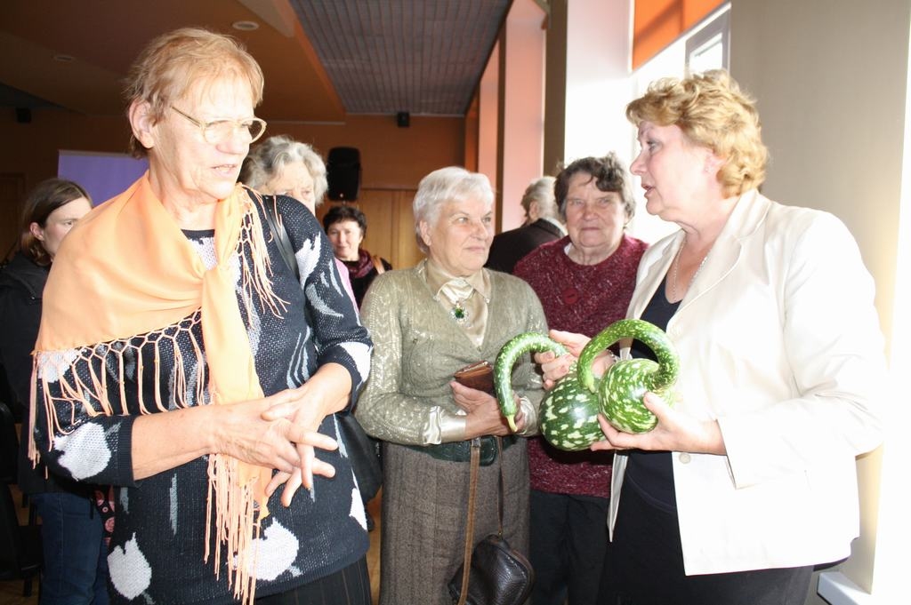 KAKLS KĀ GULBIM. “Tā ir pudeļu lagenārija — garo kaklu var sagriezt šķēlītēs un lietot pārtikā, bet resnajā daļā ir sēklas. Negatavus augļus lieto salātos un marinēšanai, bet nobriedušus — kā dekoratīvus elementus un traukus,” stāsta Edīte Seipule (no labās). No kreisās — Mārīte Rempe, Daina Bikoveca un Eleonora Moroza. 
Autors: Guna Mikasenoka