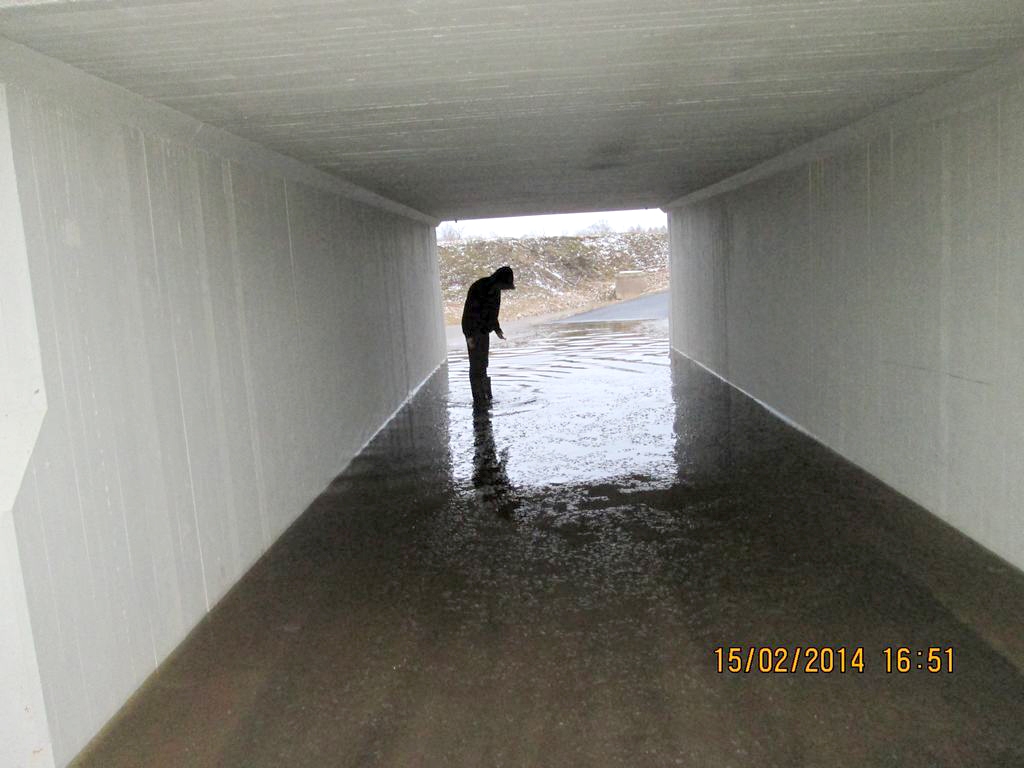 ŪDENS NEAIZTEK. Lai droši tiktu cauri gājēju tunelim, vajag garus zvejnieku zābakus. Daudzi neriskē un labāk izvēlas rāpties uz ceļa pa dubļaino uzbēruma malu.                                                       
Autors: Andra Skaba foto 