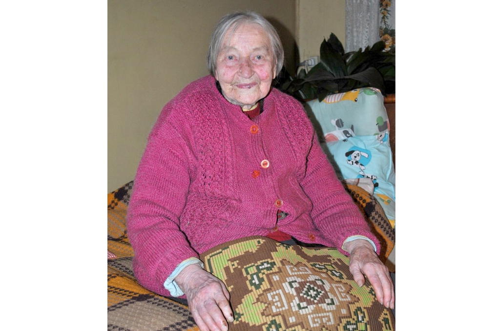 Velta Vitkovska dzimtajos “Vairogos”. Pašas austā spilvendrāna rokās. 
Autors: Līga Patmalniece