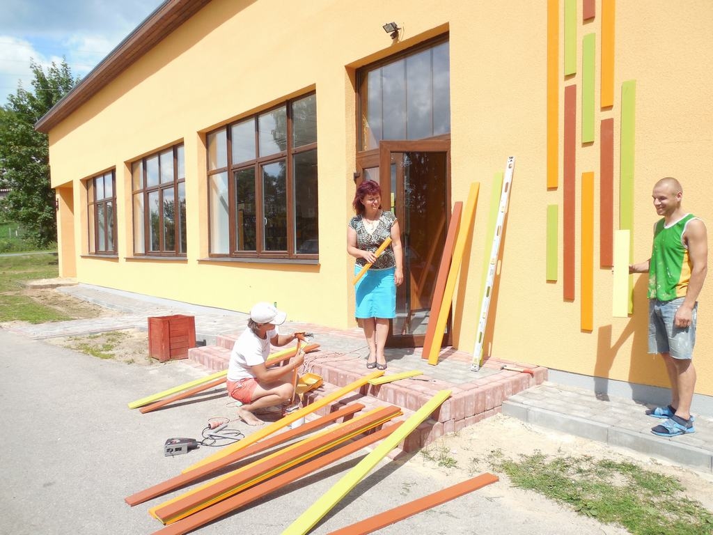 LAI IR KRĀSAINĀK. SIA “Rufs” strādnieki Indira (no kreisās) un Dmitrijs kopā ar Aiviekstes pagasta pārvaldes vadītāju Giedri Zvirgzdiņu (vidū) saskaņo ēkas fasādes krāsu pēdējos akcentus. 
Autors: Sandra Pumpure
