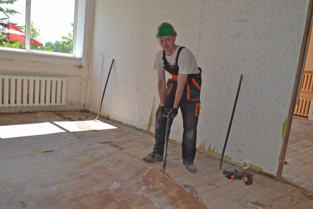 MAINA GRĪDAS SEGUMU. SIA “Simols” strādnieks Agris Skujiņš noņem veco linoleju. 
Autors: Indulis Burka