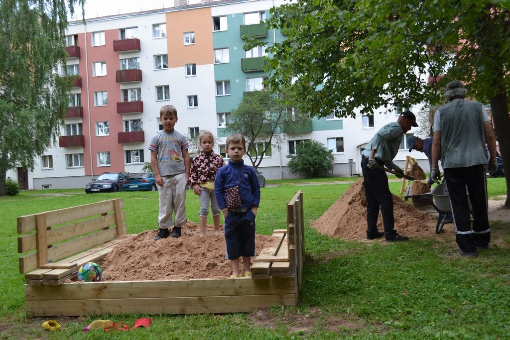 IDEJU NOSKATA INTERNETĀ. Bērni iemēģina jauno smilšu kasti. Kad tā ir atvērta, vāki kalpo kā soliņi — šāda ideja noskatīta internetā. 
Autors: Guna Mikasenoka