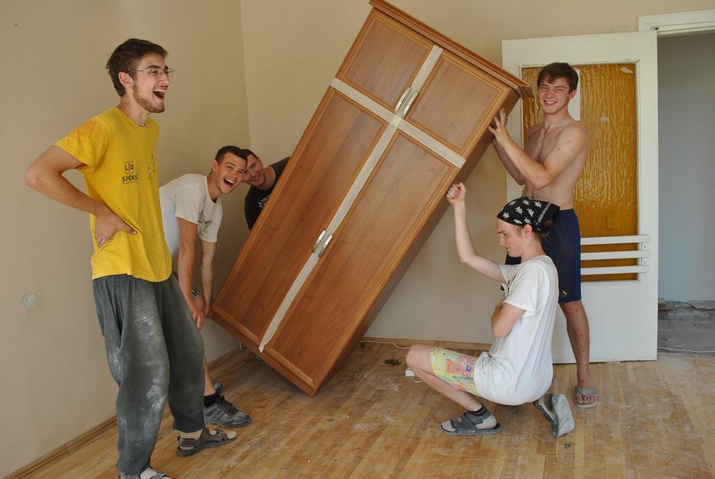 VIETĒJIE PALĪGI. Dažādus palīgdarbus veic Kokneses jaunieši, piemēram, telpās pārvieto  mēbeles. Pirms pacelt skapi, jāveic jogas vingrinājumi —  tas, protams, ir joks, bet tā darbi veicas labāk. No kreisās —  Ulvis Jaunzems, Didzis Požarskis, Antons Popovs, Kārlis Kāpiņš un Viktors Ozols.  
Autors: Guna Mikasenoka