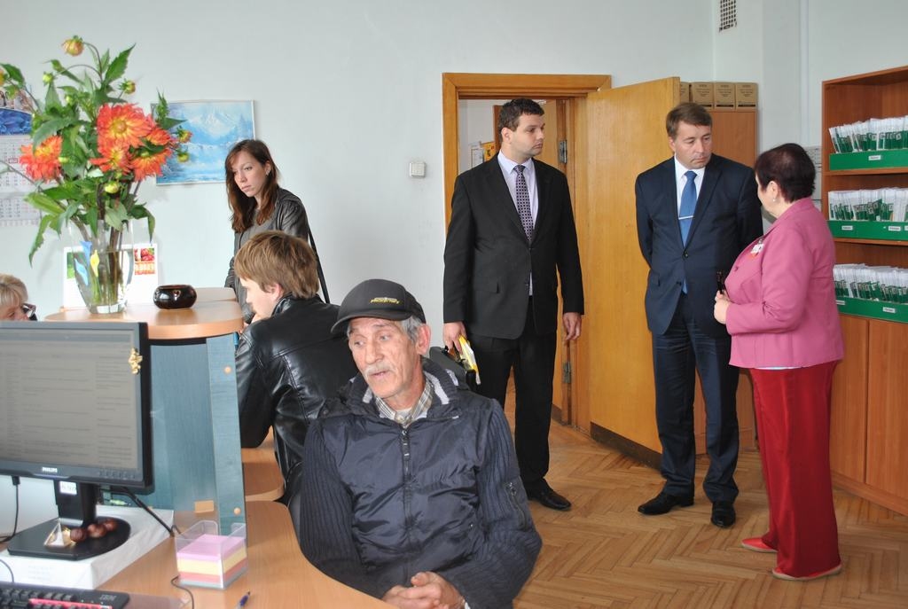 NVA Aizkraukles filiālē tik daudz klientu, ka Vasilijs Jakovļevs no Klintaines (priekšplānā) nemaz nepamana ienākam labklājības ministru Uldi Auguli — viņš runā ar filiāles vadītāju Birutu Škutāni (stāv no labās). Līdzās pa kreisi — ministra biroja vadītājs Reinis Uzulnieks. 
Autors: Guna Mikasenoka