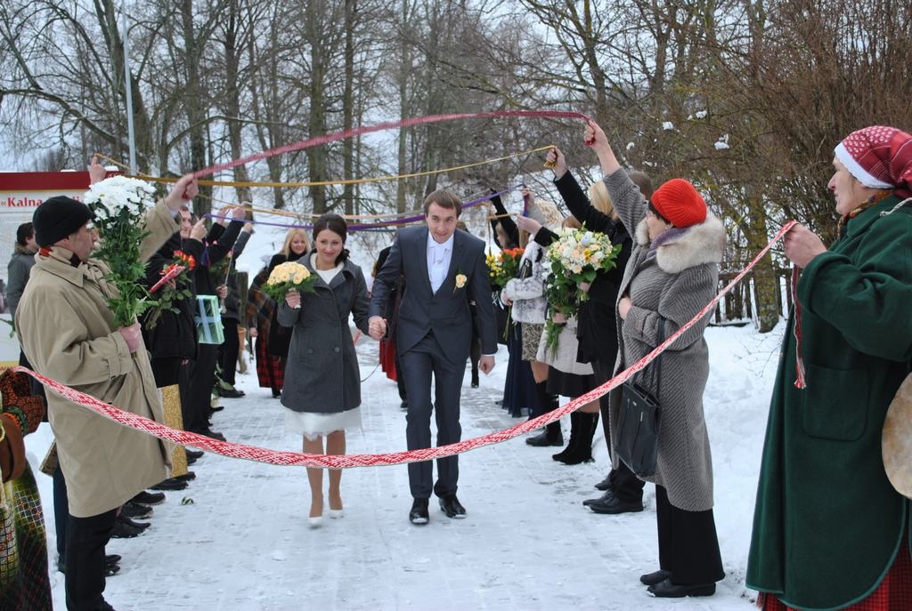 MUZEJĀ ŠOGAD PIRMAIS PĀRIS. Caur folkloras kopas “Urgas” dalībnieču un kāzu viesu veidotajiem tautisko jostu vārtiem jaunā sieva ienāk sava tautu dēla sētā. Adelīna un Miks Folkmaņi 10. janvārī salaulājās baznīcā Jēkabpilī un pa ceļam uz svinību vietu Ķegumā kopā ar kāzu viesiem Aizkraukles vēstures un mākslas muzejā sirsnīgā, gaišā, jautrā atmosfērā pavadīja apmēram divas stundas.