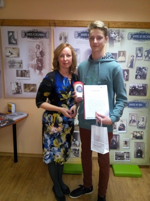 Abpusējs prieks. Termokrūze ar Kokneses novada logo, našķis, grāmata par Koknesi un apliecinājums par dalību Ēnu dienā šogad tiek Andim Benuševicam. Attēlā kopā ar Kokneses bibliotēkas pieaugušo nodaļas vecāko bibliotekāri Ingrīdu Grūbi. 

Autors: no Kokneses pagasta bibliotēkas