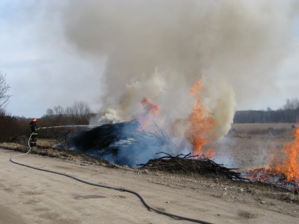 SPRAKŠĶ UN MUTUĻO. Ugunsdzēsējs Normunds Kalniņš cenšas apslāpēt liesmas, kas pārņēmušas šķeldai domātās zaru kaudzes. 

Autors: Solveiga Ivanova