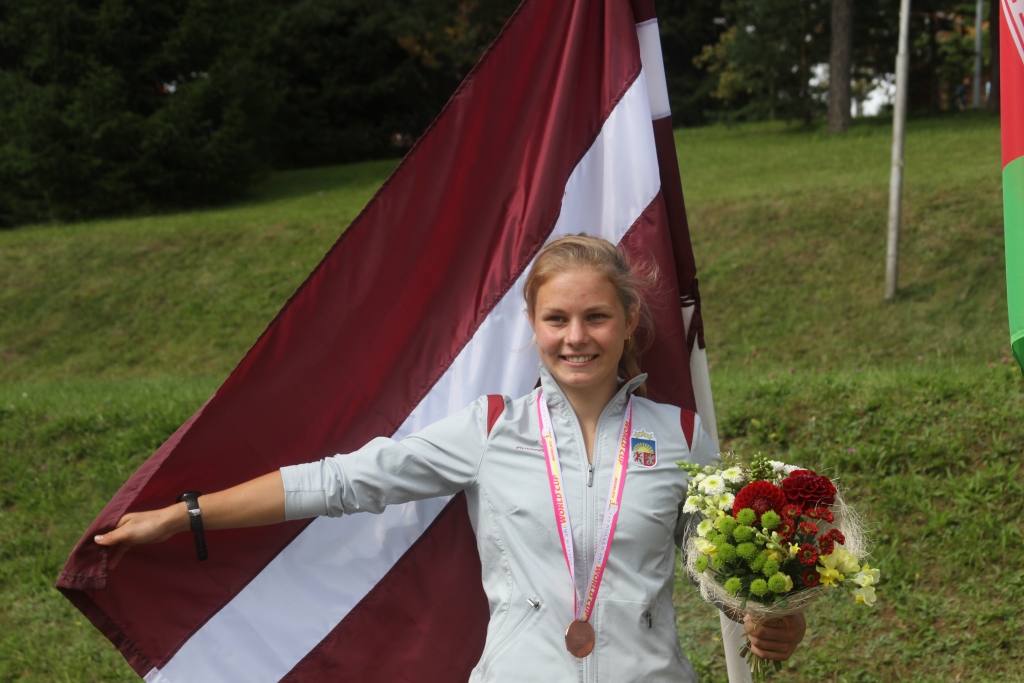 UZVAR SAVAI VALSTIJ. Patrīcija Eiduka pēc sacensībām ar bronzas medaļu pie Latvijas karoga.           
Autors: no Patrīcijas Eidukas albuma