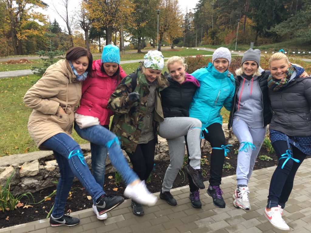 Zilā lentīte. “Pēdas” daiļās dāmas rāda komandas vienojošo elementu.
Autors: no deju kolektīva “Pēda”