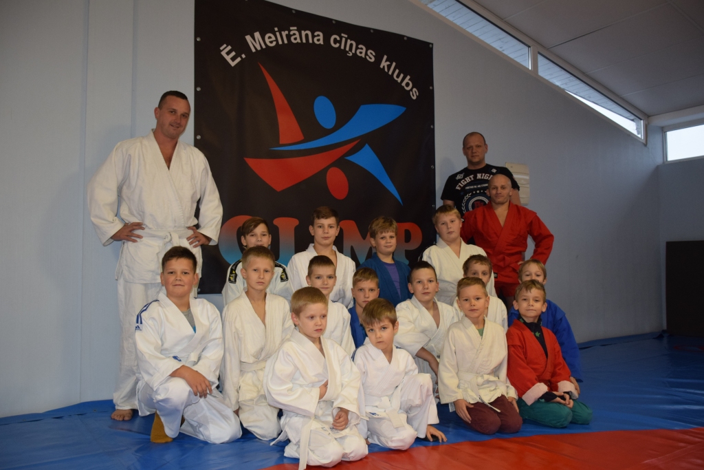 Jaunie cīnītāji. Ērika Meirāna cīņas sporta kluba audzēkņi kopā ar treneri Mihailu Šabarovu (trešajā rindā aiz zēniem no labās) un trenera palīgu Vitāliju Selicki (no kreisās).
Autors: Mihails Šabarovs