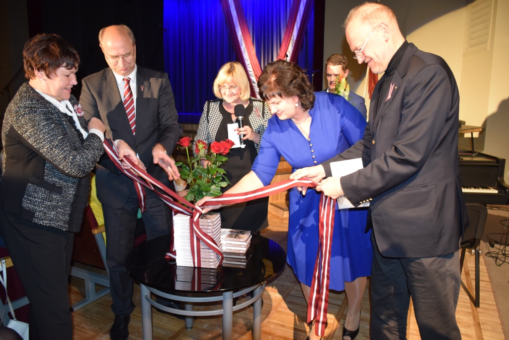 GRĀMATAS ATVĒRŠANAS SVĒTKOS. No tipogrāfijas atvestās grāmatas simboliski izsaiņo bijušā Aizkraukles mēra Viļņa Plūmes atraitne Sarmīte Plūme (no kreisās), Aizkraukles novada domes priekšsēdētājs Leons Līdums, kultūras nama direktore Anta Teivāne, autore Linda Šmite un izdevniecības “Jumava” valdes loceklis Juris Visockis. 
Autors: Guna Mikasenoka