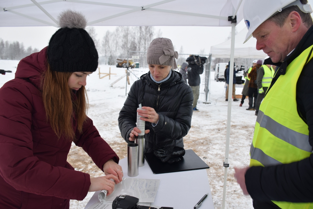 Vēstījums likteņdārza pamatos. SIA “RRKP būve” valdes priekšsēdētājs Aigars Kalniņš (no labās), Kokneses fonda valdes priekšsēdētāja Valda Auziņa un Ance Seikstule ievieto laika kapsulā vēstījumu, kuru parakstījuši visi pasākuma dalībnieki.
Autors: Līga Patmalniece