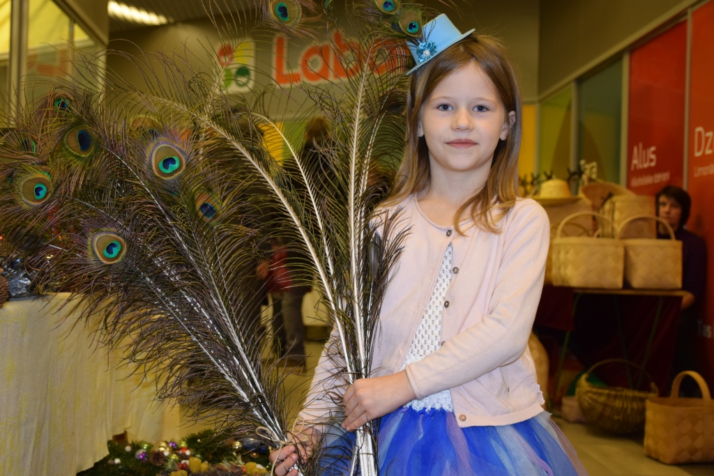 SIMPĀTISKĀ STAIGĀJOŠĀ REKLĀMA. Astoņgadīgā Renāte Onzule labprāt demonstrē pāvu skaistās rotas un mammas darinājumus.  
Autors: Guna Mikasenoka
