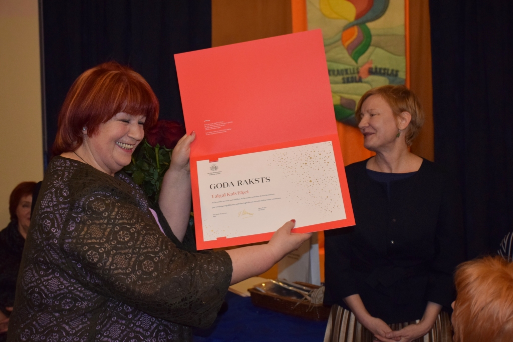Pateicība no Rīgas ciemiņiem. Ilggadējā skolas direktore Taiga Kalvišķe (no kreisās) apsveikumā saņēma Latvijas Naci­onālā kultūras centra goda rakstu.